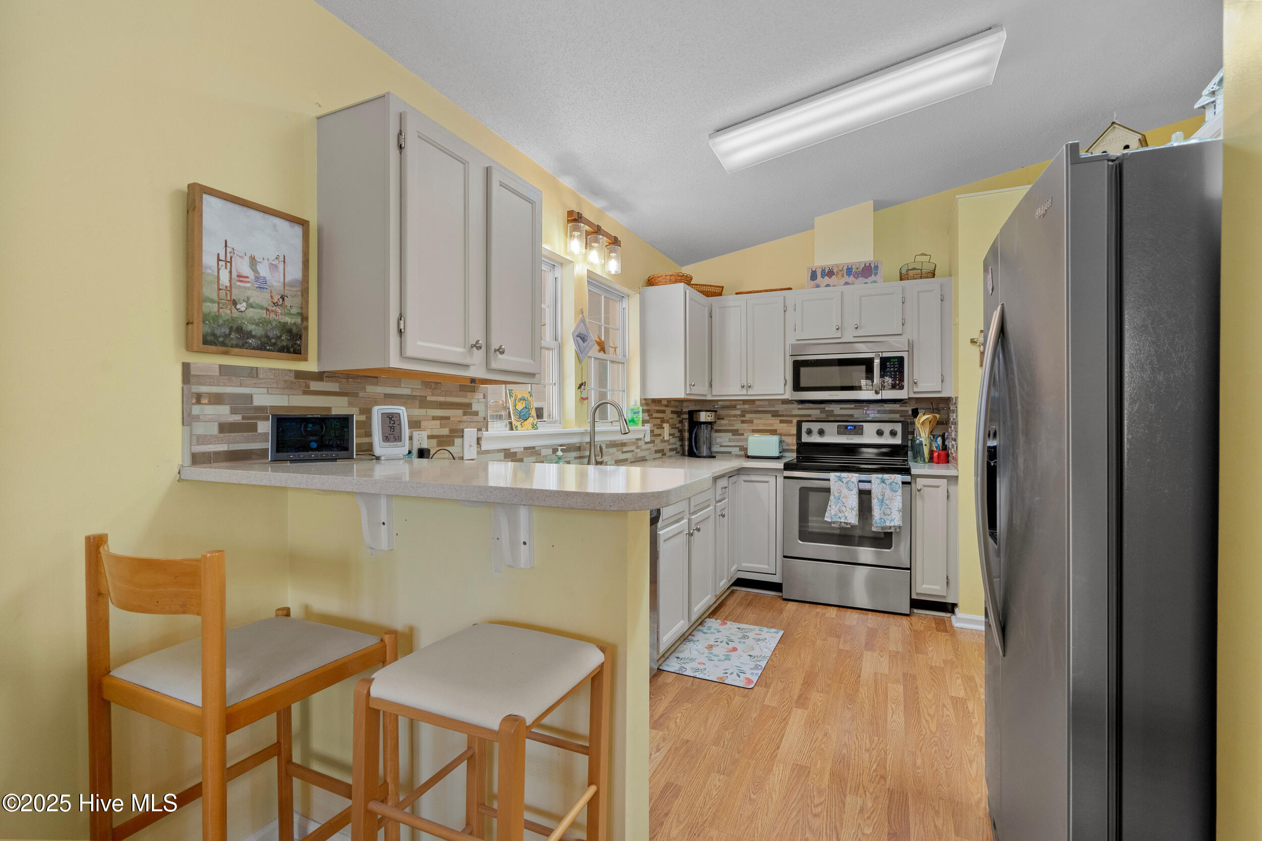 396 Deer Path Calabash, NC 28467 - Photo 7 of 33 This kitchen features stainless steel appliances, solid surface countertops, a skylight, and a stylish backsplash.