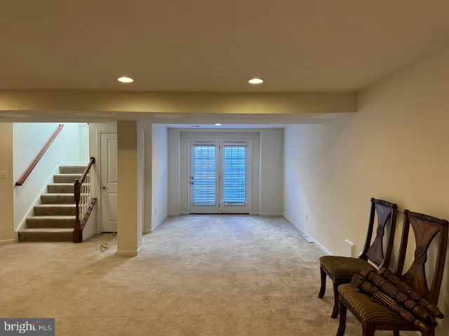 a view of an empty room with stairs and furniture
