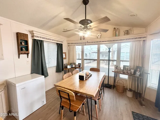 a dining room with wooden floor and large windows