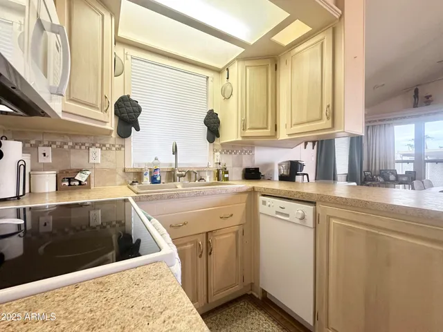 a bedroom with two beds and a lamp on dresser