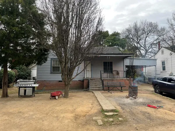 a view of a house with a yard and sitting area