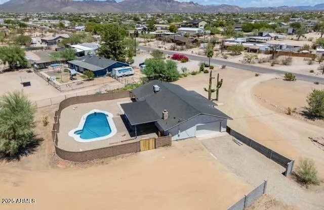 an empty room with wooden floor chandelier fan and windows
