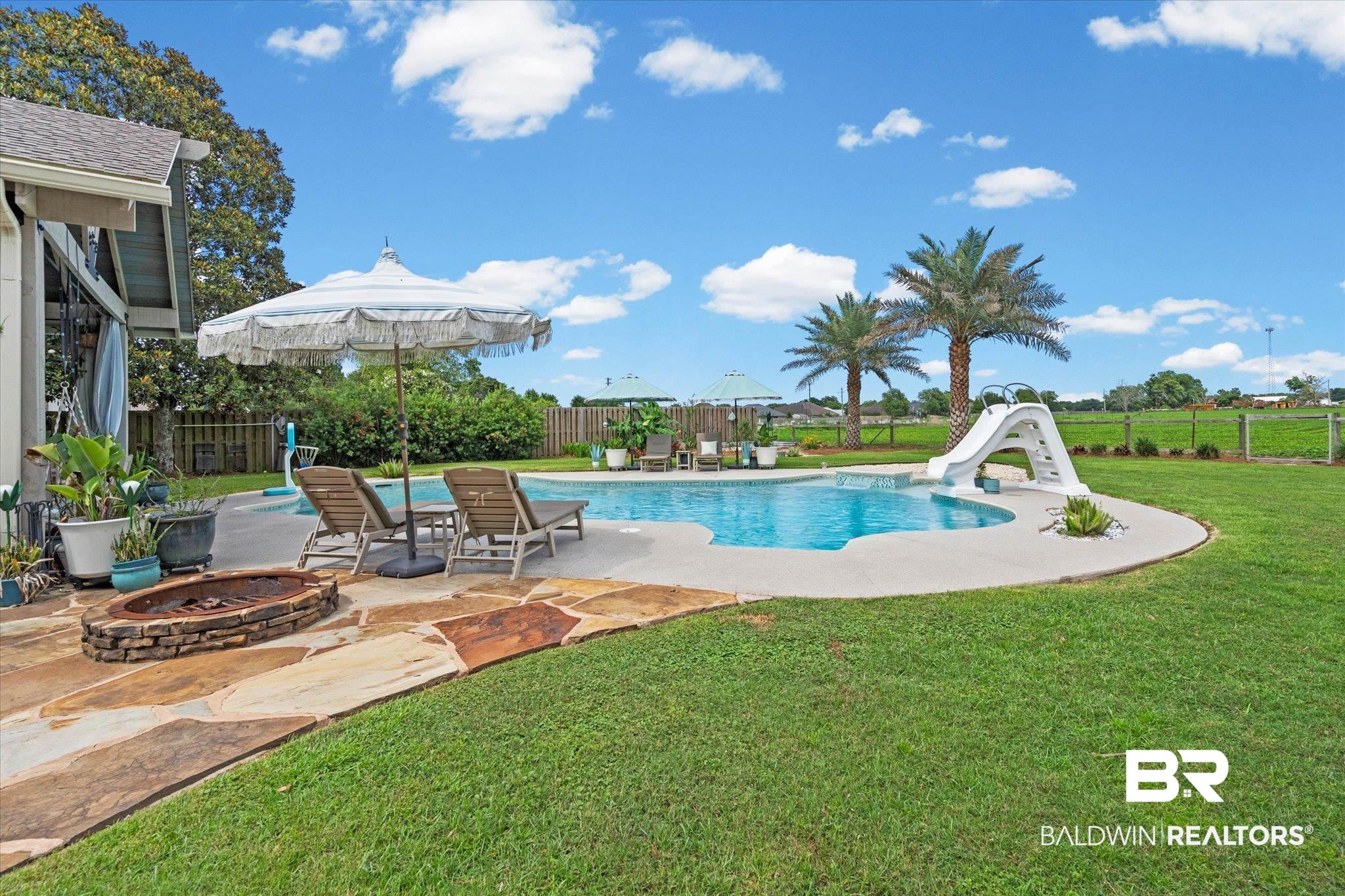 24908 Bosbyshell Avenue Daphne, AL 36526 - Photo 29 of 49 Backyard oasis featuring an in-ground swimming pool with an attached slide, surrounded by a concrete patio