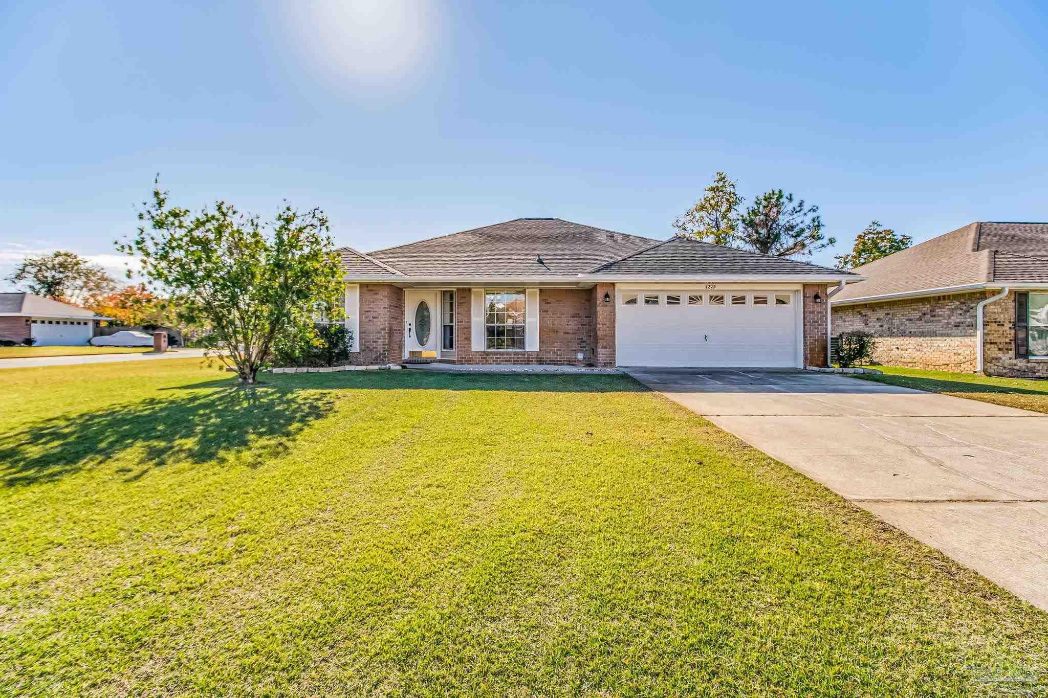 a front view of a house with yard and swimming pool