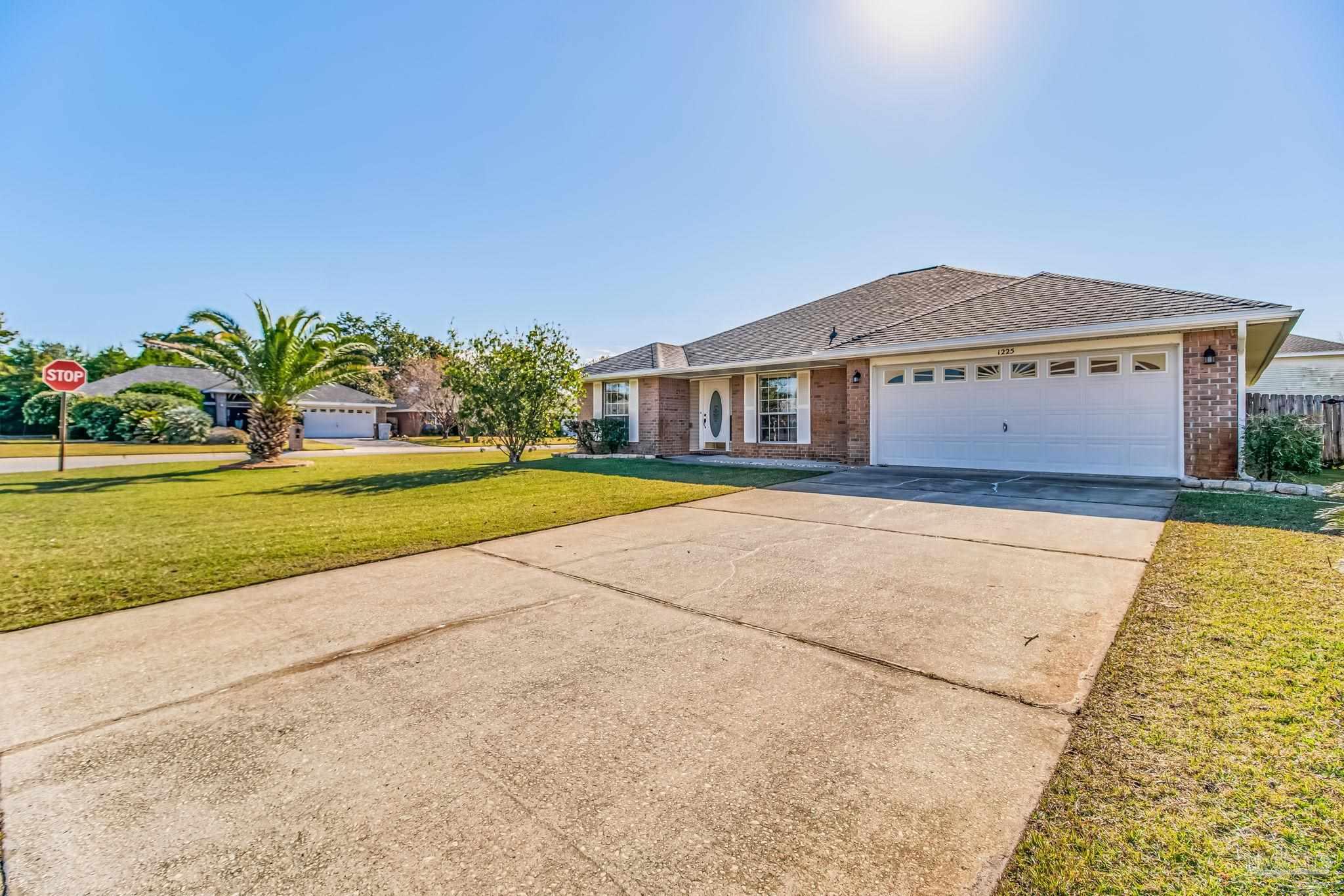 1225 Grand Ridge Circle Gulf Breeze, FL 32563 - Photo 3 of 29 a front view of a house with a yard and palm trees