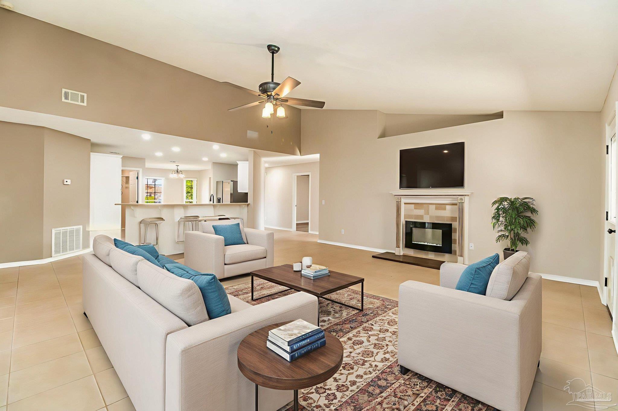 1225 Grand Ridge Circle Gulf Breeze, FL 32563 - Photo 5 of 29 a living room with furniture a fireplace and a flat screen tv