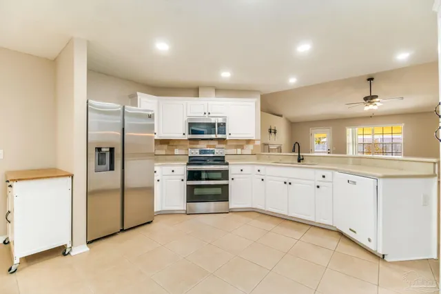 a kitchen with granite countertop white cabinets and stainless steel appliances