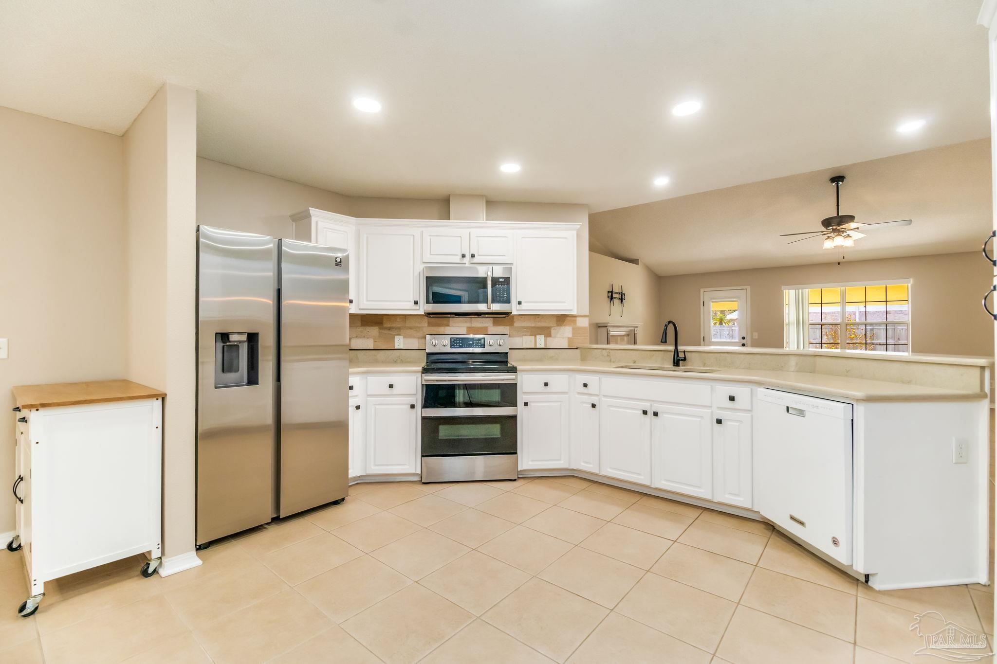 1225 Grand Ridge Circle Gulf Breeze, FL 32563 - Photo 7 of 29 a kitchen with granite countertop white cabinets and stainless steel appliances