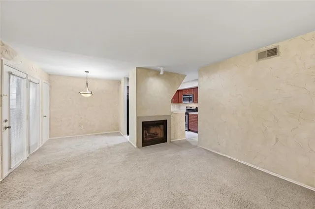 an empty room with a fireplace and a window