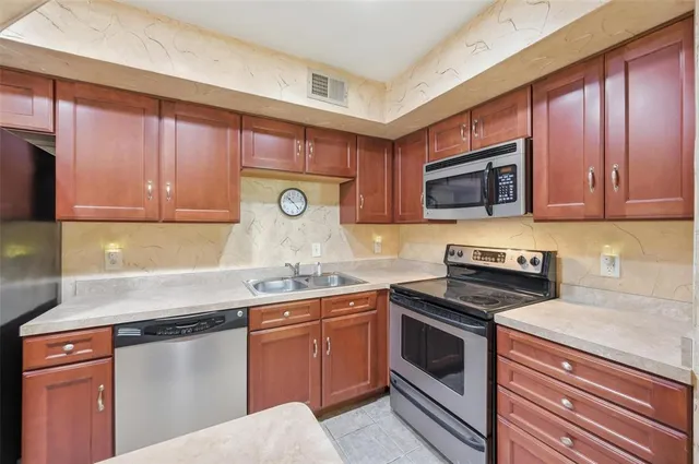 a kitchen with granite countertop cabinets stainless steel appliances and a sink
