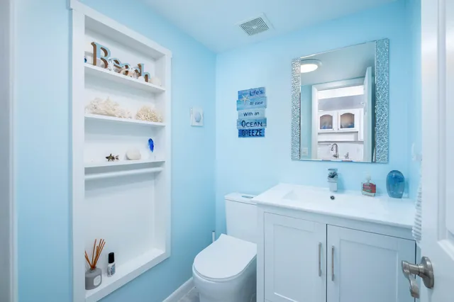 a bathroom with a sink a toilet and a mirror