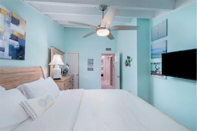 a bedroom with a bed and a flat tv screen on the dresser