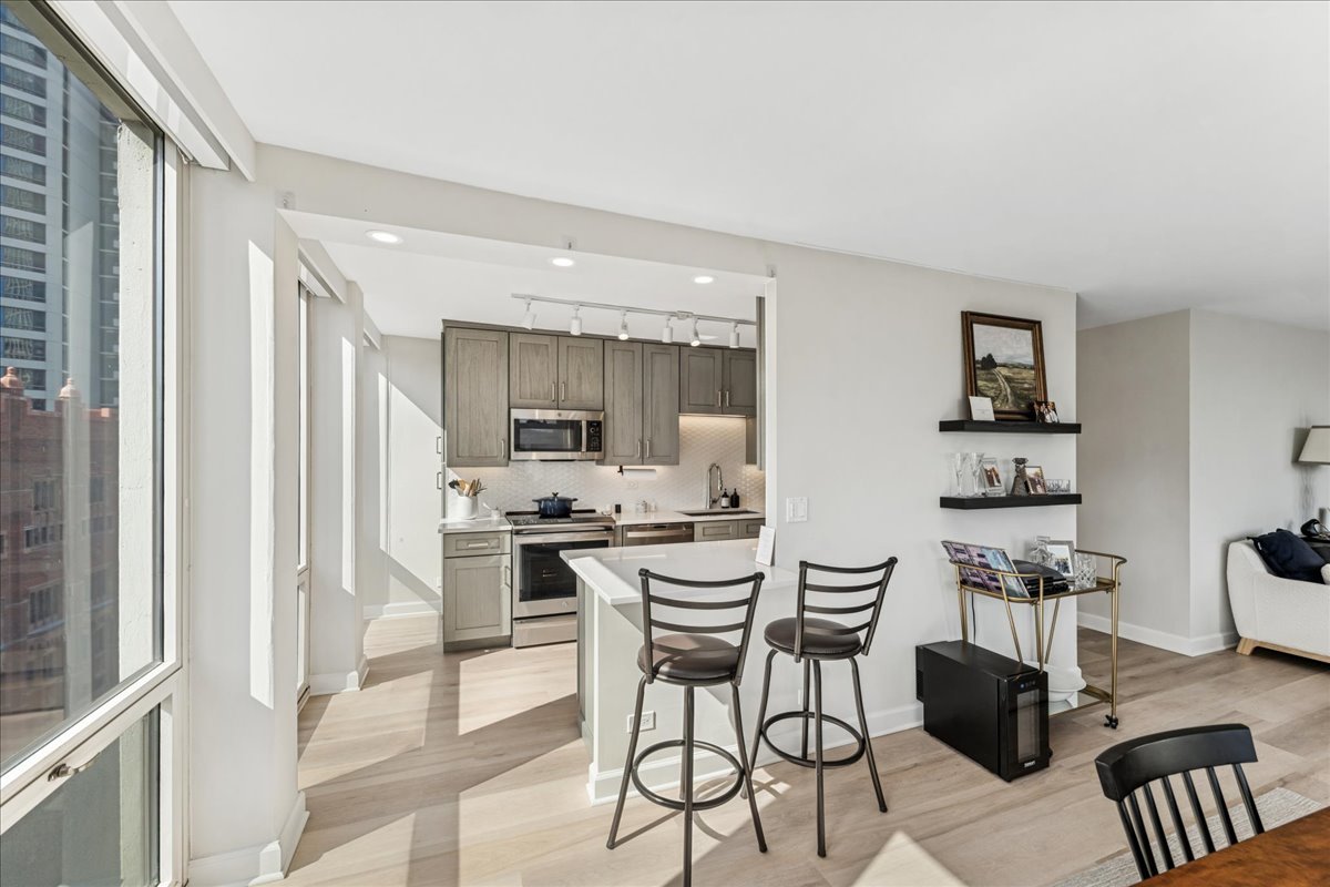 111 East Chestnut Street, Unit 22K Chicago, IL 60611 - Photo 14 of 20 a kitchen with stainless steel appliances kitchen island granite top and refrigerator