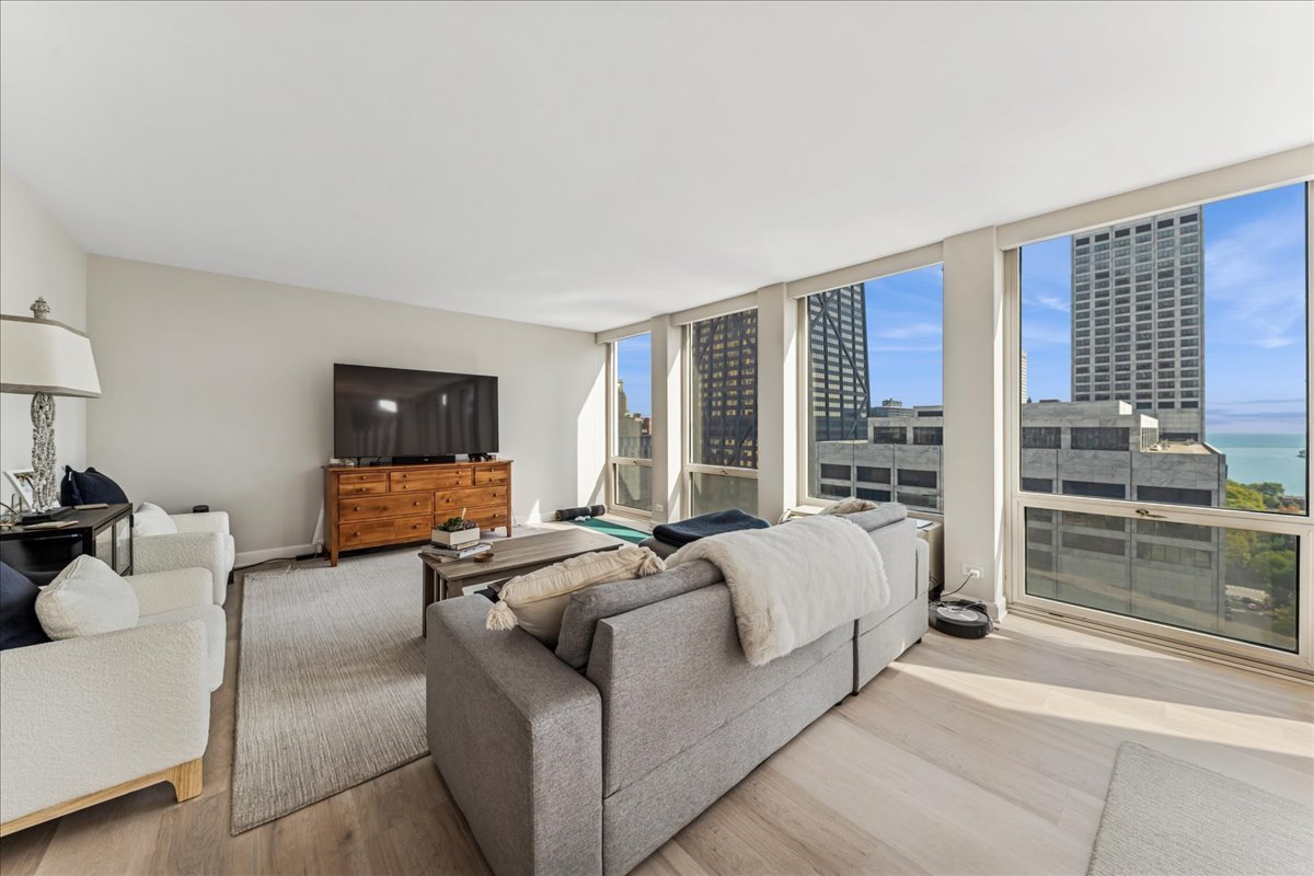 111 East Chestnut Street, Unit 22K Chicago, IL 60611 - Photo 2 of 20 a living room with furniture and a flat screen tv