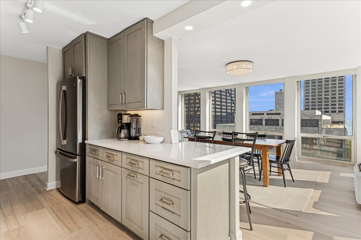 111 East Chestnut Street, Unit 22K Chicago, IL 60611 - Photo 6 of 20 a kitchen with a sink stove and chairs