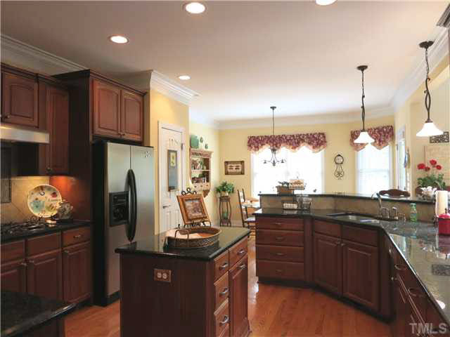 7209 Sparhawk Road Wake Forest, NC 27587 - Photo 8 of 25 The Kitchen features w/lots of 42" cherry cabinets, granite ctrs, detailed tile backsplash and stainless steel appliances (including gas cooktop, wall oven, range hood, microwave & dishwasher). Kitchen