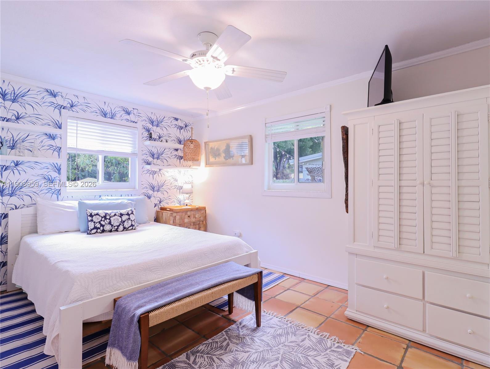 160 Ridge Street Tavernier, FL 33070 - Photo 13 of 24 a bedroom with a bed a chandelier and dresser