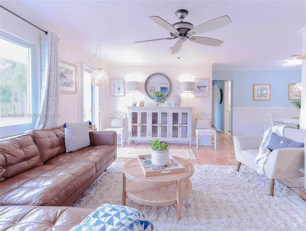 a living room with furniture a large window and a chandelier