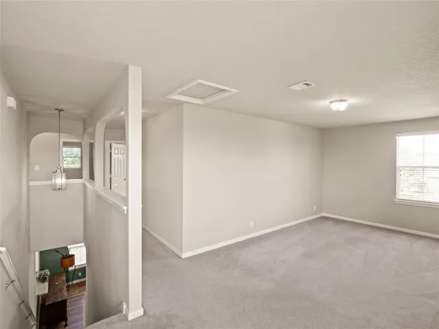 an empty room with a window and a ceiling fan