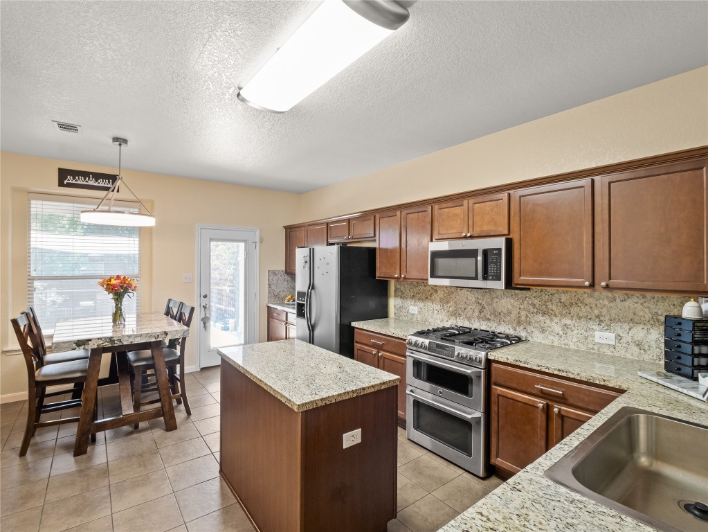 102 Wisteria Way San Marcos, TX 78666 - Photo 6 of 29 a kitchen that has a lot of cabinets in it and appliances