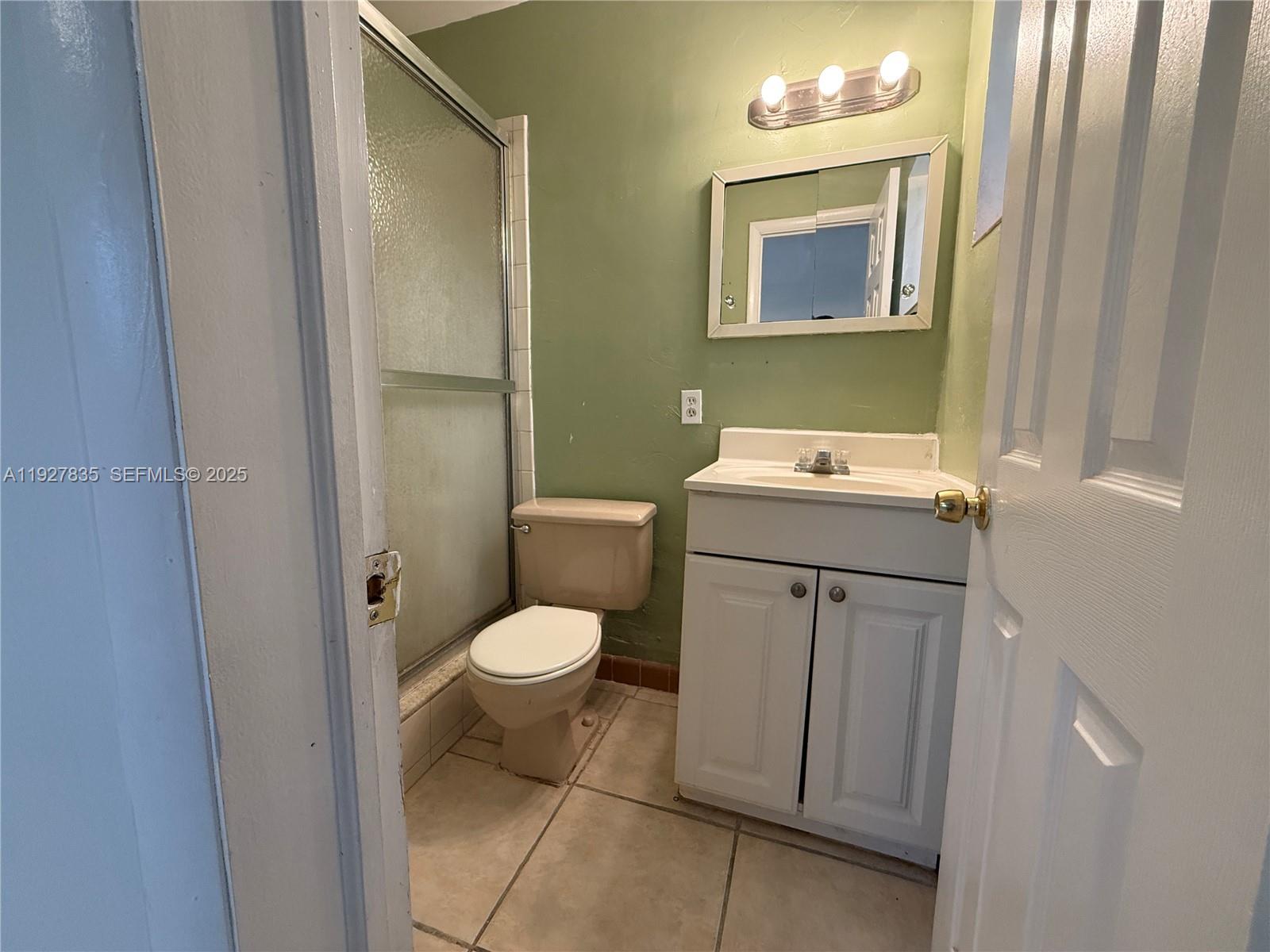 301 North 70th Avenue Hollywood, FL 33024 - Photo 12 of 14 a bathroom with a toilet sink and mirror