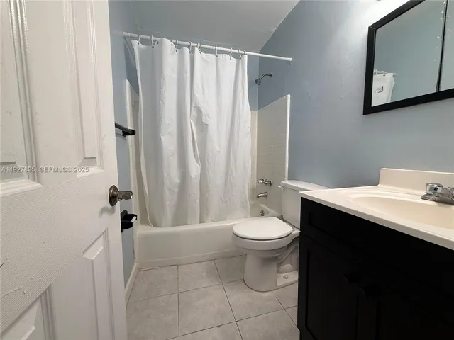 a bathroom with a sink a toilet and shower curtain