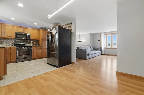 a kitchen with kitchen island granite countertop a stove sink and refrigerator