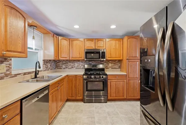a kitchen with stainless steel appliances granite countertop a stove a sink and a refrigerator