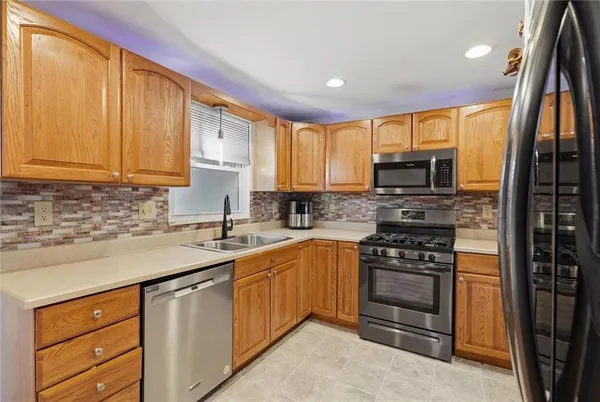 a kitchen with stainless steel appliances granite countertop a stove a sink dishwasher and a refrigerator