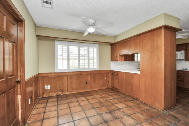 a view of an empty room with window and cabinet