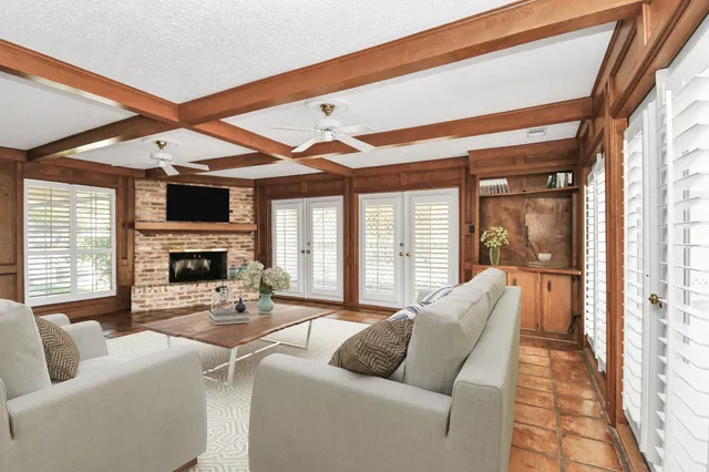 a living room with furniture a fireplace and a large window
