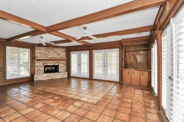 a view of an empty room with a fireplace and a window