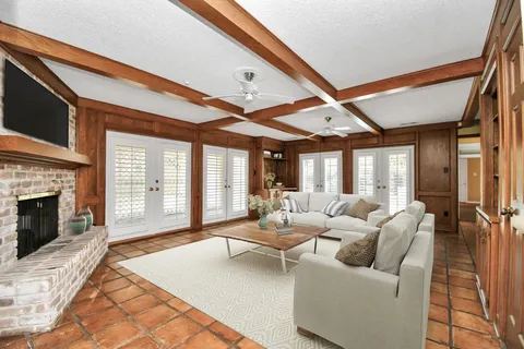a living room with furniture a fireplace and a floor to ceiling window