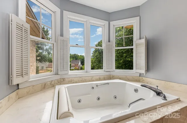 a bathroom with bathtub a window and a shower