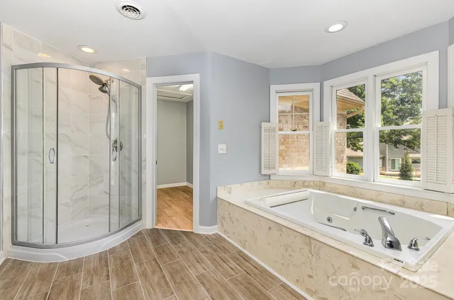 a bathroom with a tub a sink and a large mirror