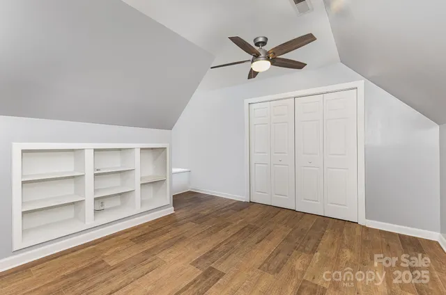 a view of a big room with wooden floor closet and windows