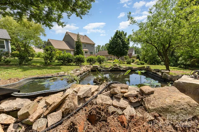 an aerial view of a house with swimming pool and trees