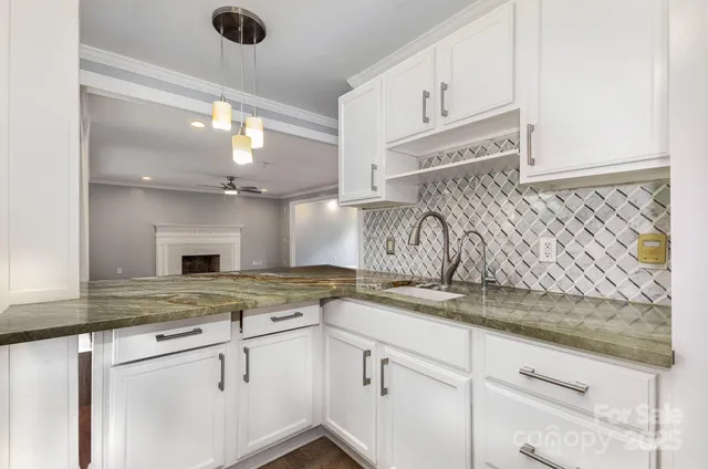 a kitchen with granite countertop white cabinets and white appliances