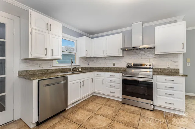 a kitchen with granite countertop white cabinets and stainless steel appliances