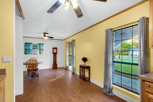 a view of a livingroom with a ceiling fan & hardwood floor