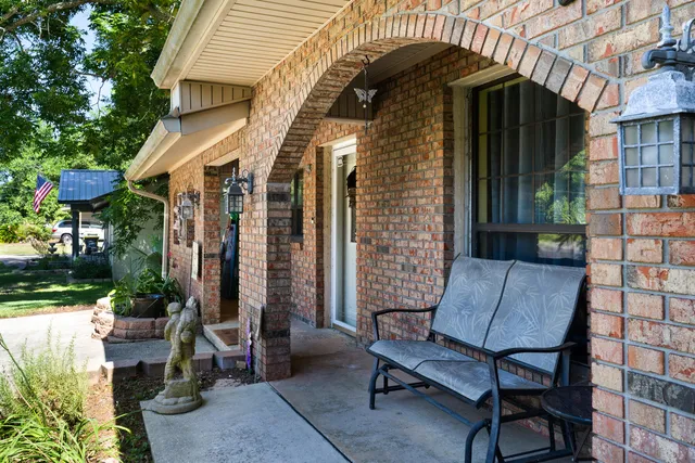 a patio with a table and chairs and potted plants