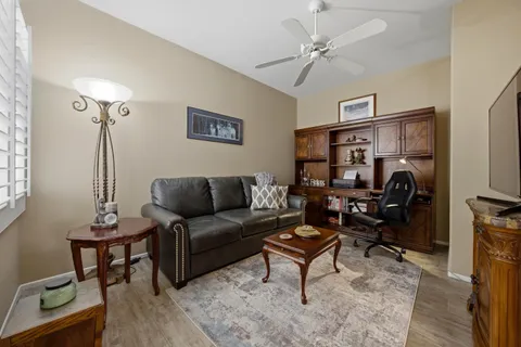 a living room with furniture a ceiling fan and a rug