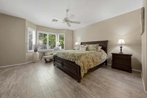 a bedroom with a bed lamp and a large window