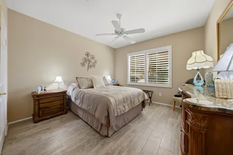 a spacious bedroom with a bed a chandelier and a large window