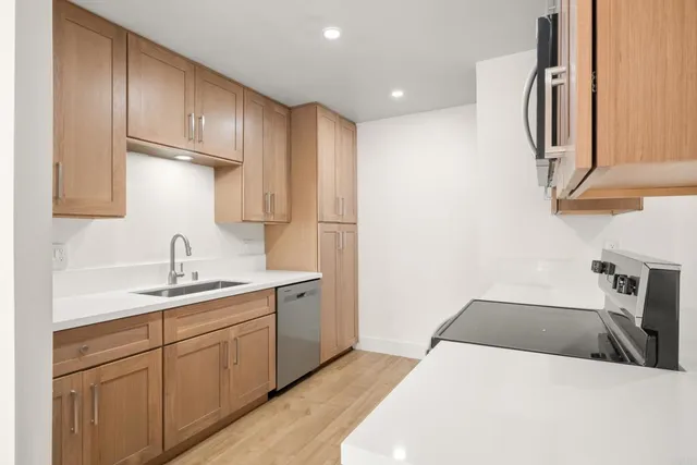 a kitchen with a sink a refrigerator and cabinets