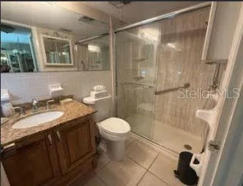 a bathroom with a granite countertop sink toilet and shower