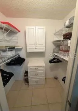 a kitchen with a refrigerator and white cabinets