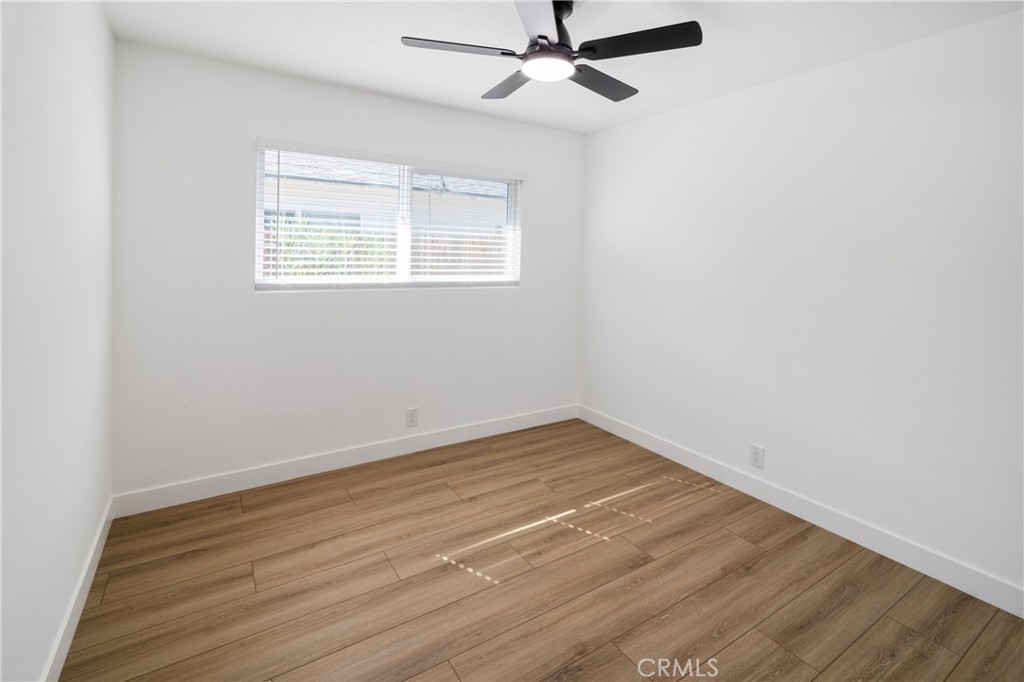 11452 Earlham Street Orange, CA 92869 - Photo 21 of 30 an empty room with wooden floor ceiling fan and windows