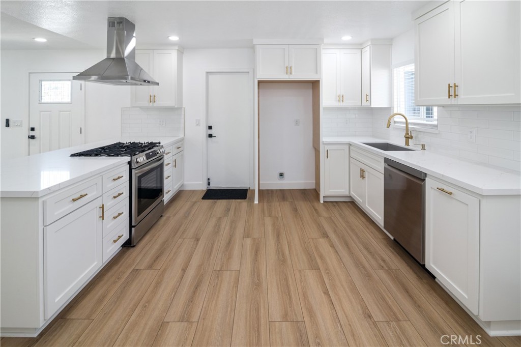 11452 Earlham Street Orange, CA 92869 - Photo 8 of 30 a kitchen with stainless steel appliances a stove top oven a sink and cabinets