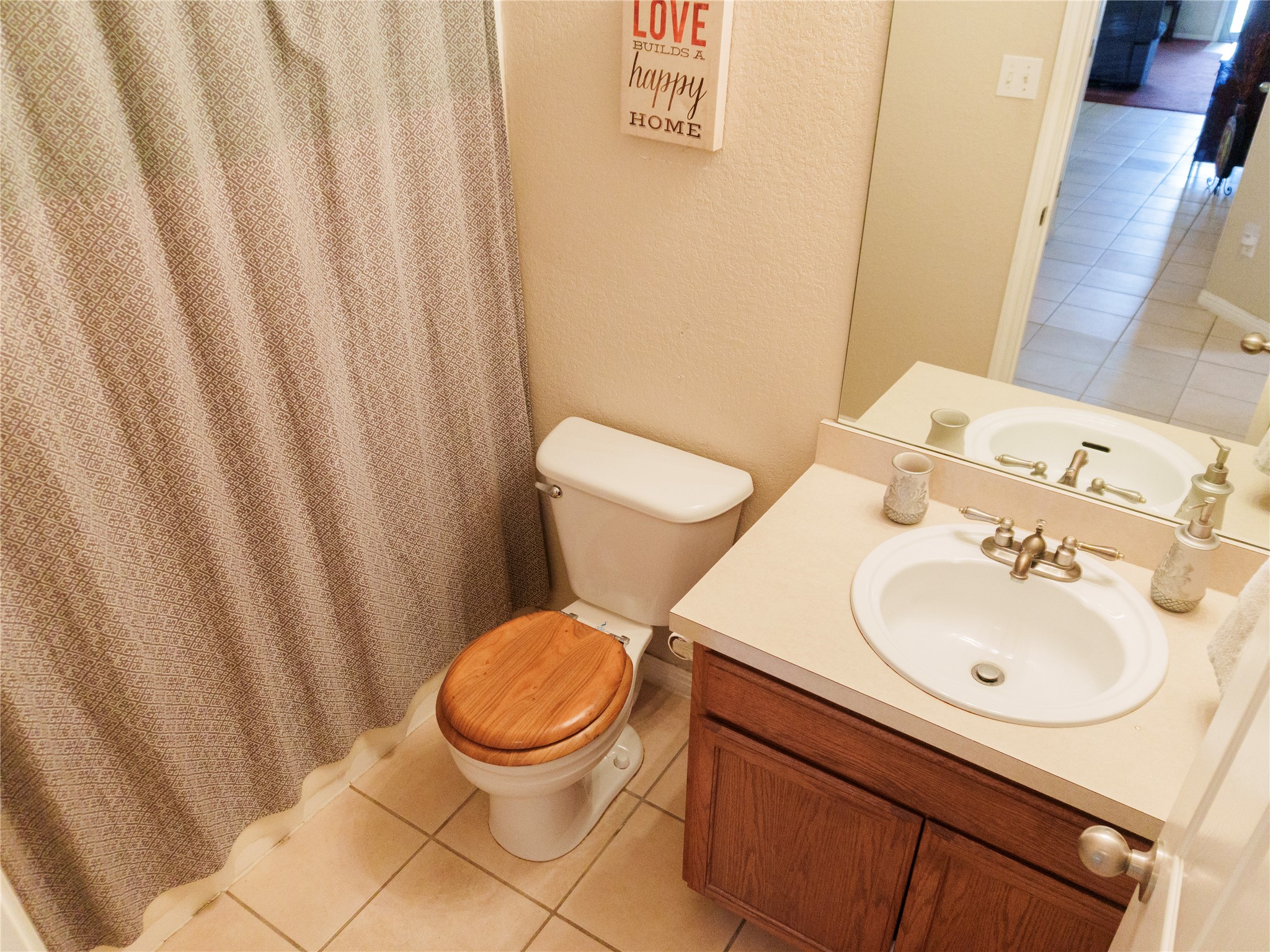 800 Debra Drive Taylor, TX 76574 - Photo 12 of 17 Bathroom with light tile patterned floors, vanity, a shower with curtain, and a textured wall